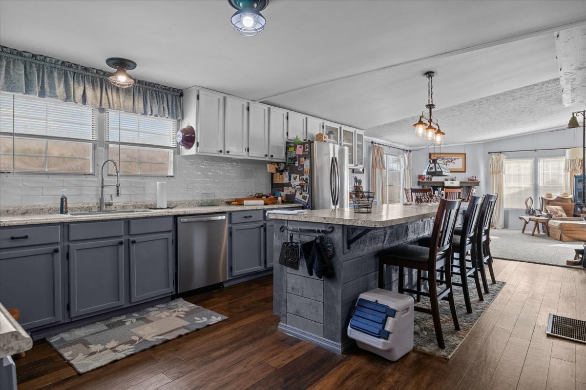 25 Cardinal Road Linden, TN 37096 - Photo 13 of 84 a kitchen with granite countertop a stove a sink dishwasher a dining table and chairs with wooden floor