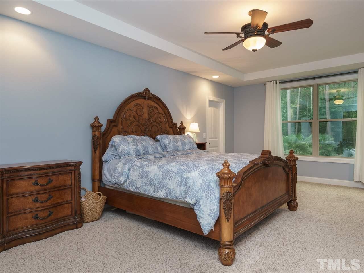 4844 Inwood Road Raleigh, NC 27603 - Photo 11 of 25 a bed sitting in a room next to a window and a chandelier