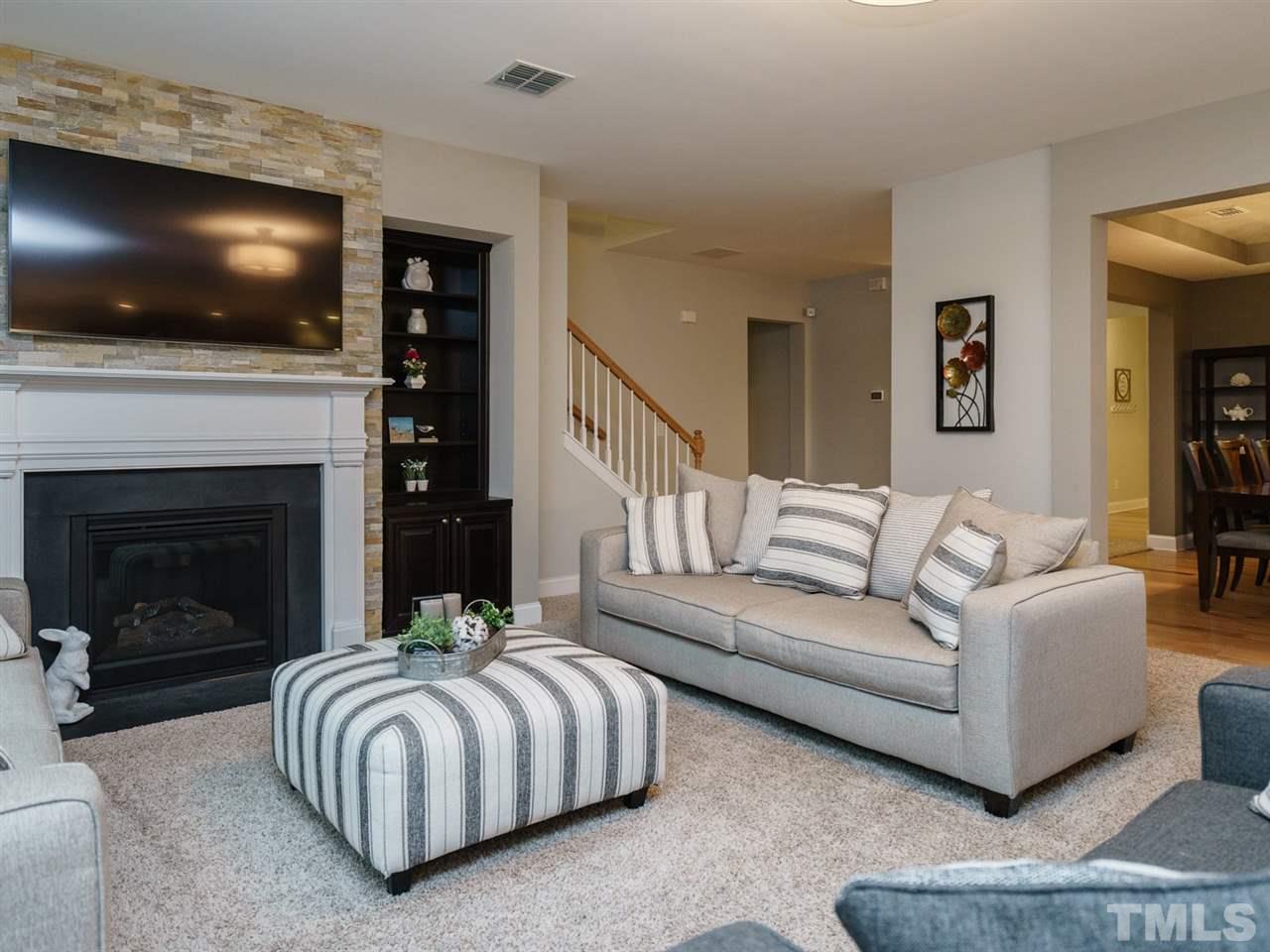 4844 Inwood Road Raleigh, NC 27603 - Photo 9 of 25 a living room with a flat screen tv and a fireplace