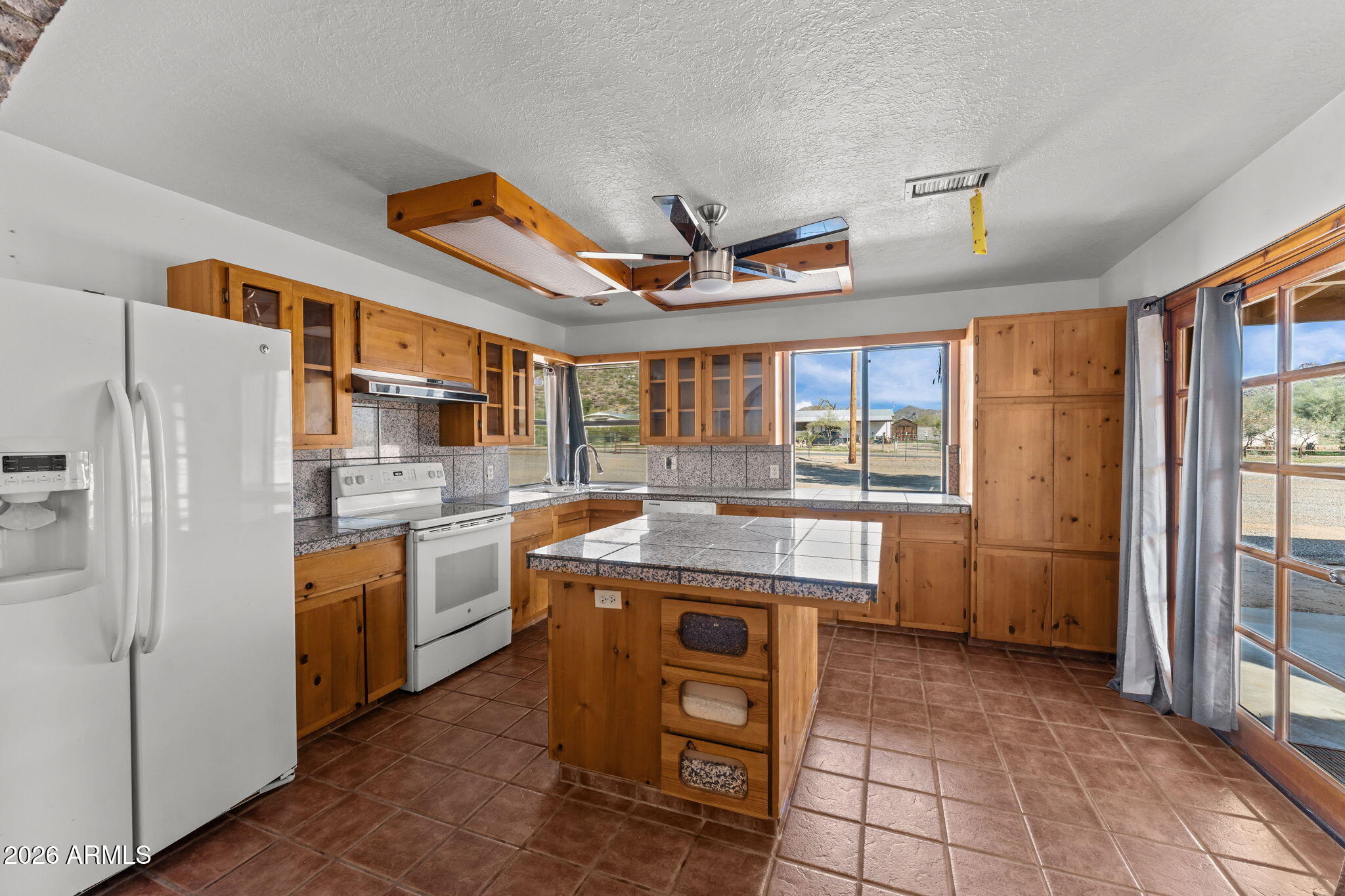 22905 Ranch Road Congress, AZ 85332 - Photo 11 of 26 a kitchen with refrigerator cabinets and large window