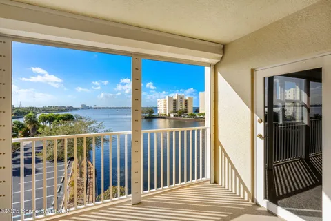 a view of a balcony with floor to ceiling window wooden floor and fence