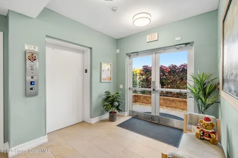 an entryway with a flower pot and a living room view