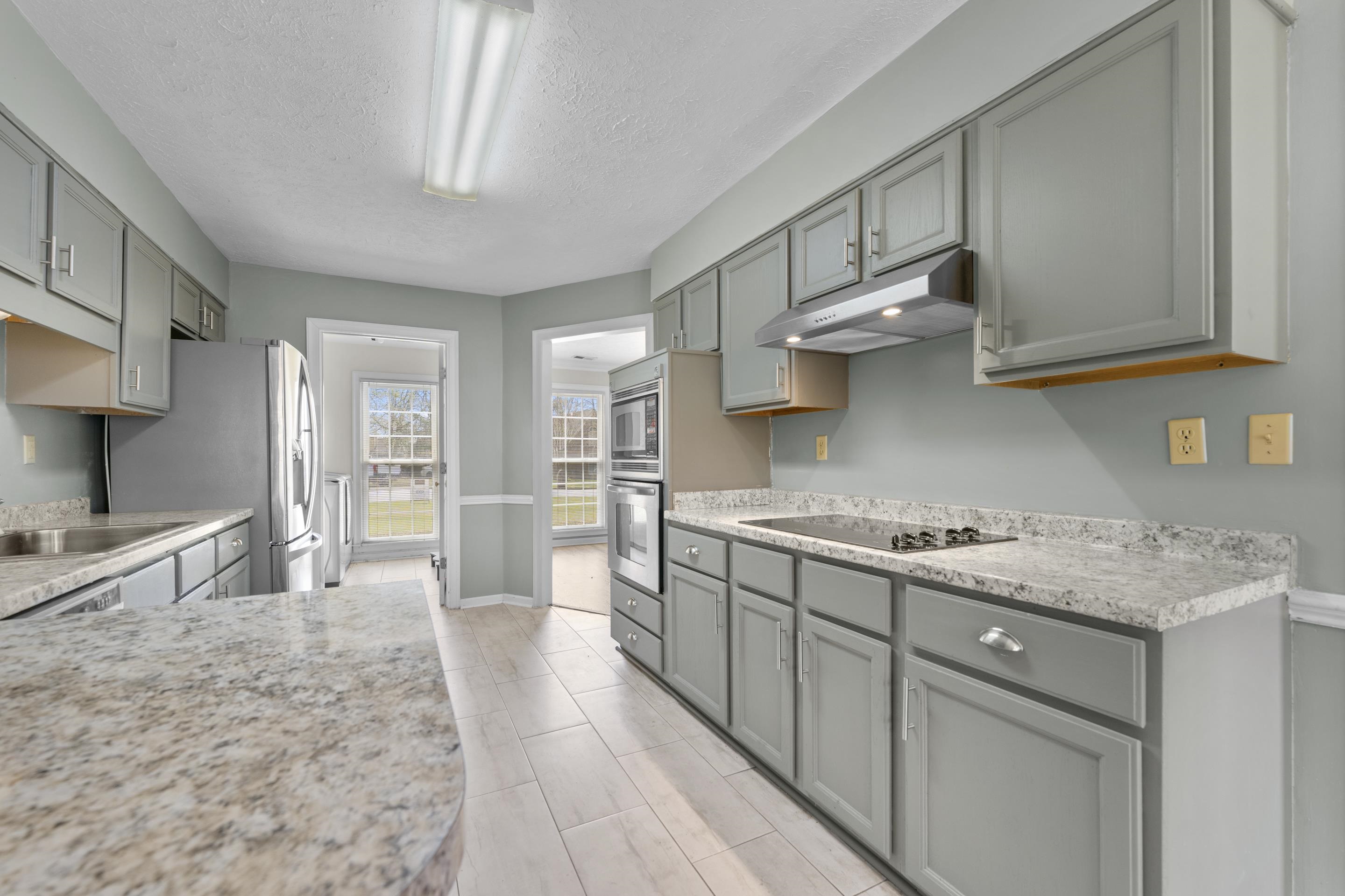 8956 Meadow Ridge Cove East Memphis, TN 38016 - Photo 11 of 28 a kitchen with stainless steel appliances granite countertop a lot of counter space and wooden floors