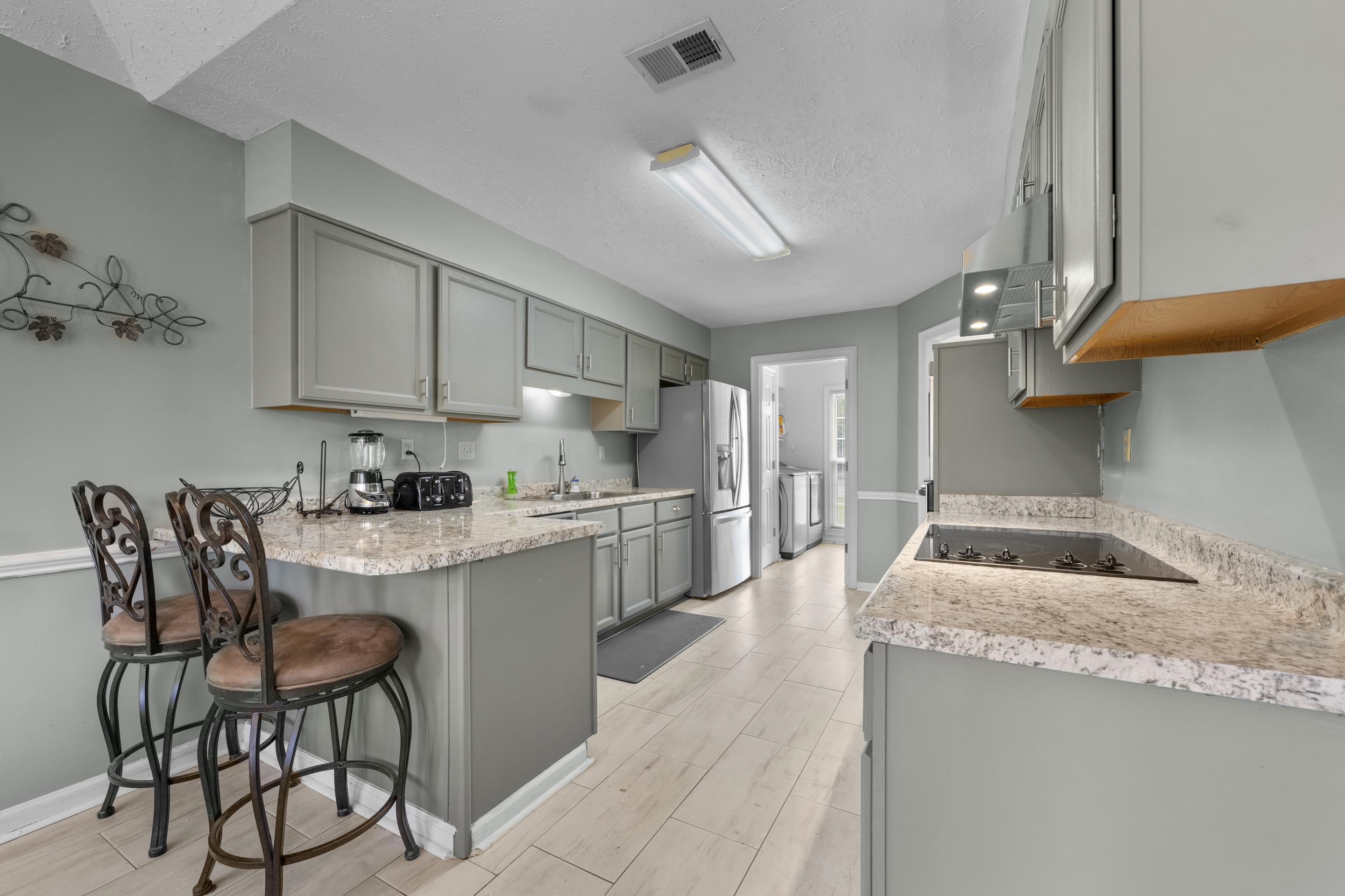 8956 Meadow Ridge Cove East Memphis, TN 38016 - Photo 12 of 28 a kitchen with stainless steel appliances granite countertop a table chairs sink and cabinets