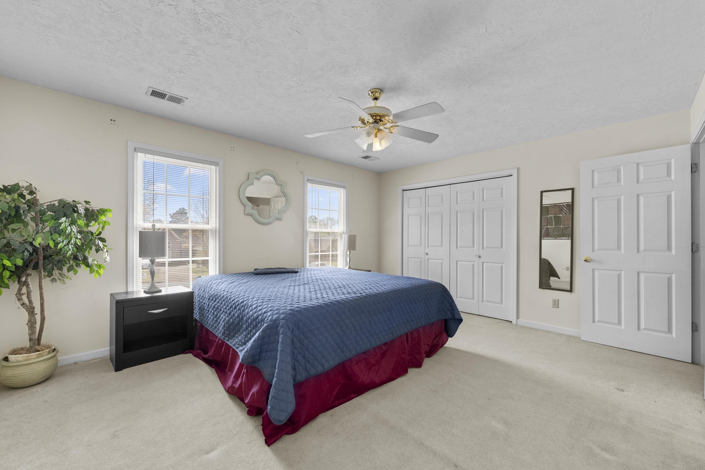 8956 Meadow Ridge Cove East Memphis, TN 38016 - Photo 20 of 28 a spacious bedroom with a bed and a potted plant