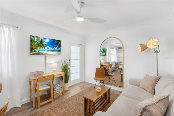 a kitchen with stainless steel appliances granite countertop a white refrigerator a stove a dining table and chairs with wooden floor