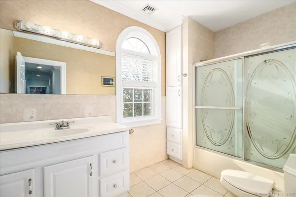 a bathroom with a granite countertop sink mirror vanity and toilet