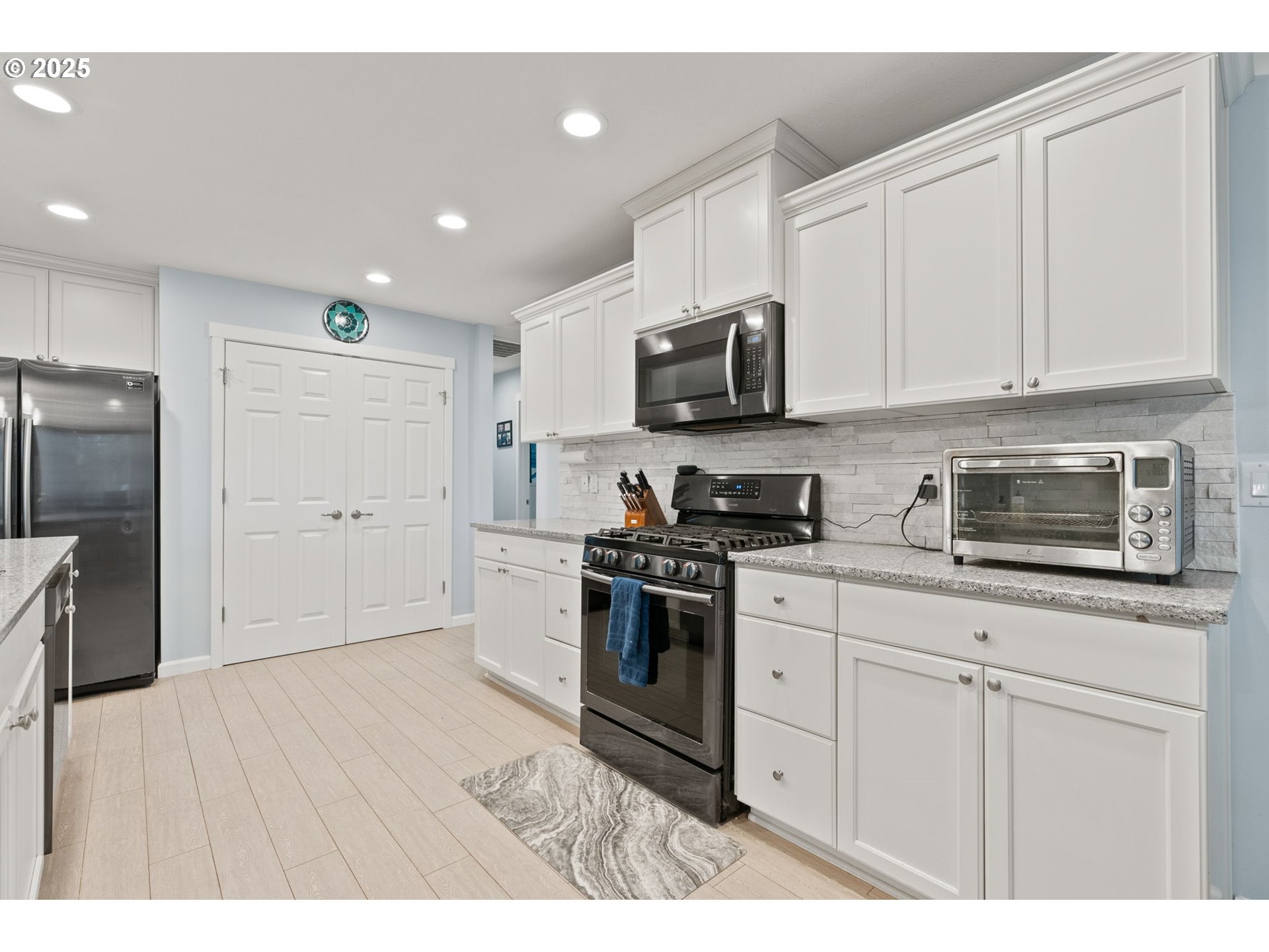 10360 Skyview Road Tillamook, OR 97141 - Photo 16 of 47 a kitchen with stainless steel appliances granite countertop a refrigerator a sink a stove a microwave and white cabinets