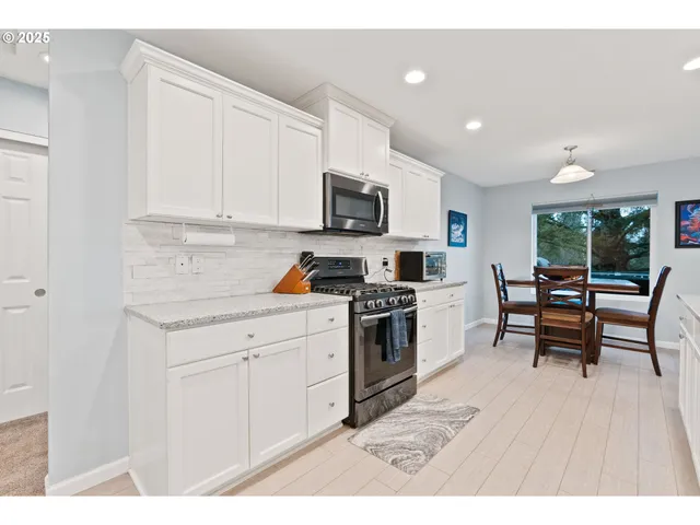 a kitchen with stainless steel appliances kitchen island granite countertop a stove a sink and a microwave