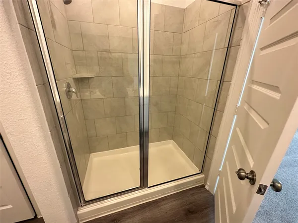 a bathroom with a glass door shower and sink