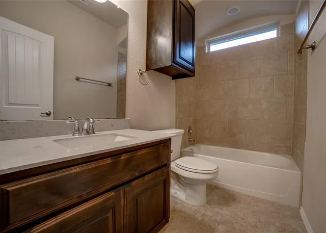 a bathroom with a granite countertop sink toilet and a mirror