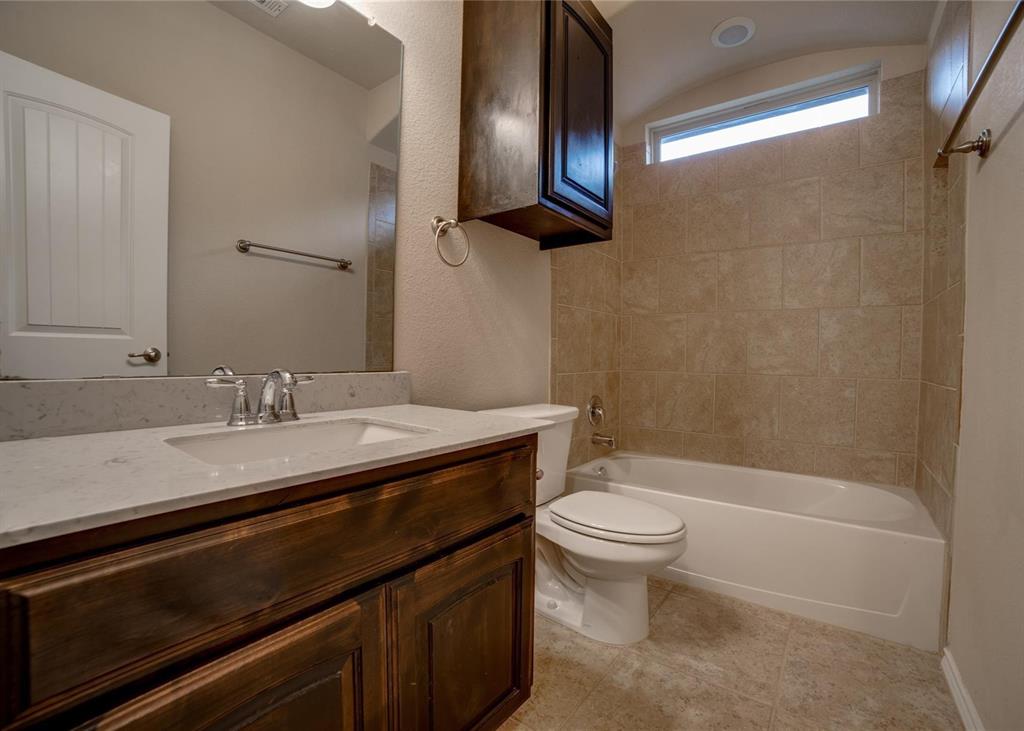2408 Windhaven Drive Denton, TX 76210 - Photo 12 of 13 a bathroom with a granite countertop sink toilet and a mirror