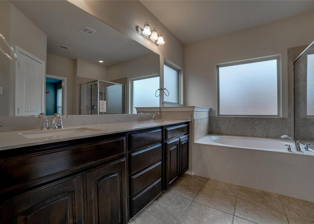 2408 Windhaven Drive Denton, TX 76210 - Photo 7 of 13 a bathroom with a bathtub double vanity sink and a large mirror
