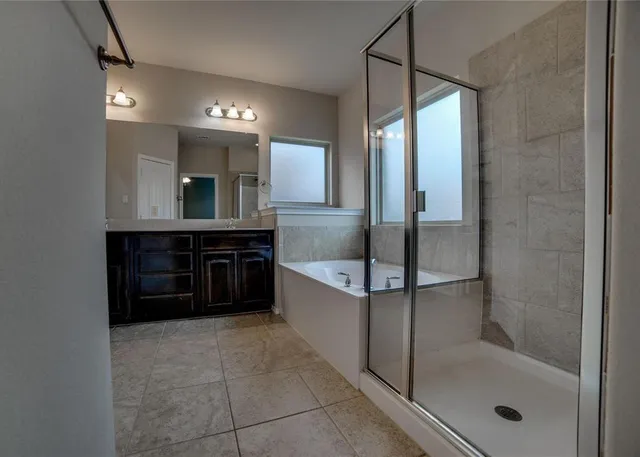 a bathroom with a tub sink shower and mirror