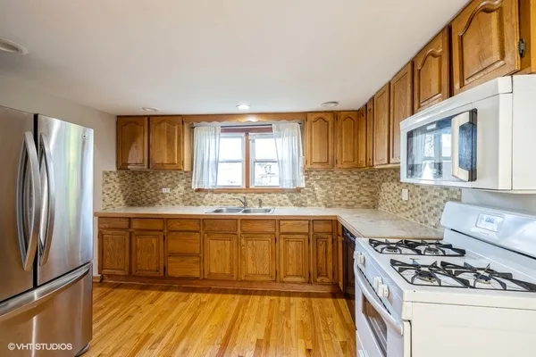 a kitchen with stainless steel appliances granite countertop a stove a sink dishwasher and a refrigerator