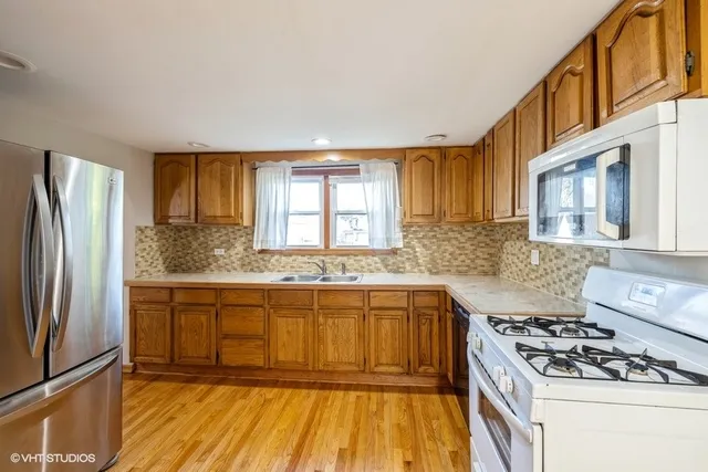 a kitchen with stainless steel appliances granite countertop a stove a sink dishwasher and a refrigerator
