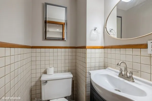 a bathroom with a sink a toilet and a mirror