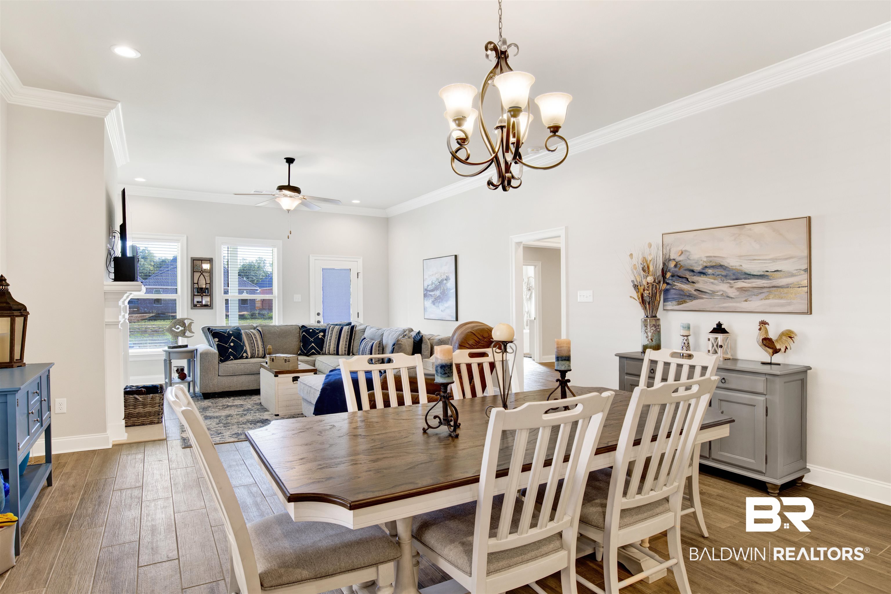 1406 Aldon Street Foley, AL 36535 - Photo 10 of 30 Dining room featuring ceiling fan with notable chandelier, crown molding, and luxury wood-look tile flooring.