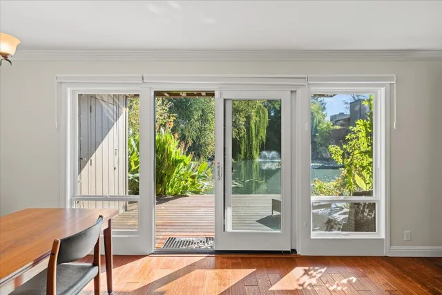 a view of an next to a room with wooden floor and windows