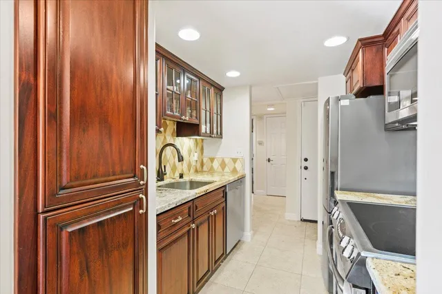 a kitchen with stainless steel appliances granite countertop a refrigerator and a sink