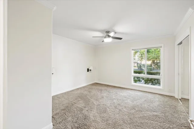 an empty room with windows and ceiling fan view