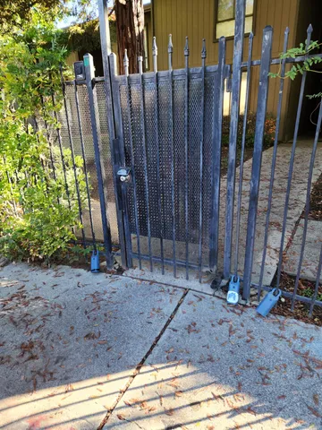 a view of a backyard with potted plants and wooden fence