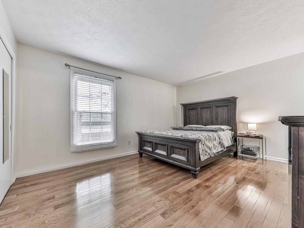 6700 Roswell Road, Unit 24E Atlanta, GA 30328 - Photo 3 of 14 a bedroom with a bed wooden floor and window