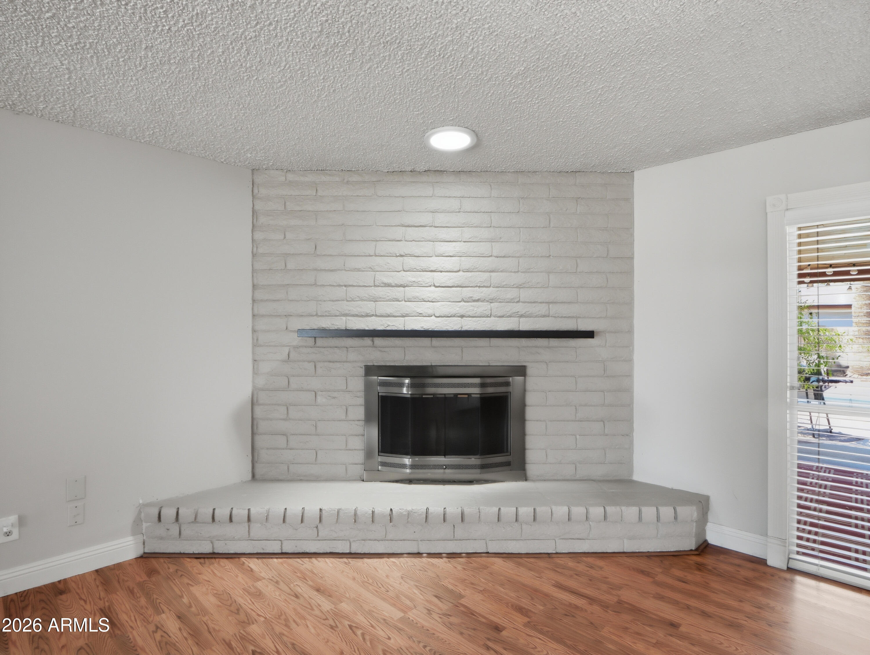 450 Cascada Road Litchfield Park, AZ 85340 - Photo 10 of 40 a living room with a fireplace and wooden floor