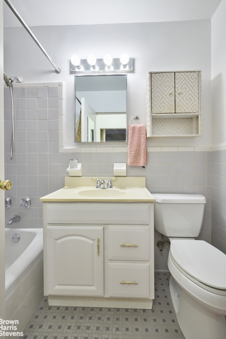 123 East 75th Street, Unit 6A Manhattan, NY 10021 - Photo 3 of 5 a bathroom with a sink a toilet a mirror and vanity