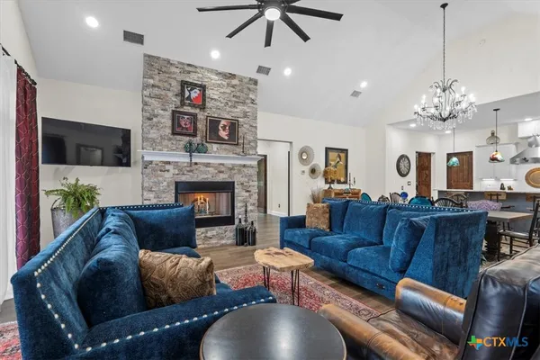 a living room with furniture a flat screen tv and a fireplace