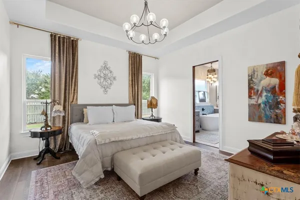 a bedroom with a bed and a chandelier