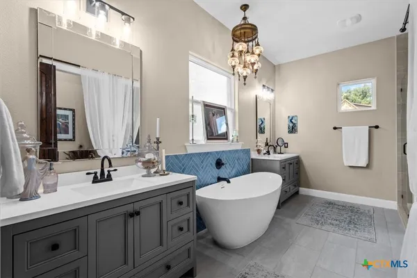 a bathroom with a double vanity sink mirror and bathtub