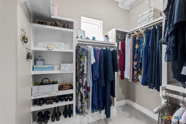 a view of walk in closet with clothes and shoes