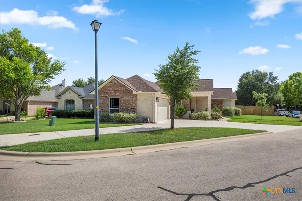 a front view of a house with a yard and trees