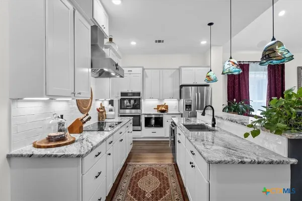 a large kitchen with lots of counter space and stainless steel appliances