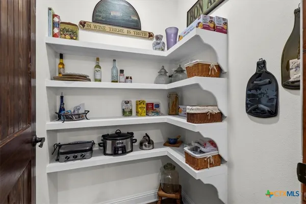 a room with a fridge and a wooden floor
