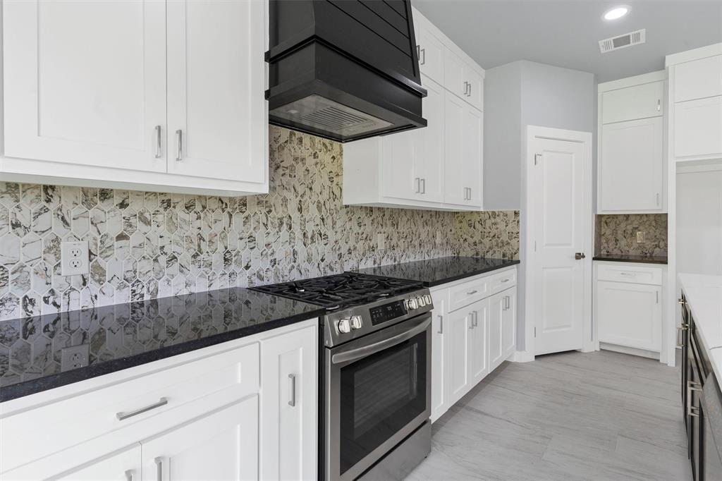 588 Highview Court Godley, TX 76044 - Photo 13 of 38 a kitchen with granite countertop white cabinets and stainless steel appliances