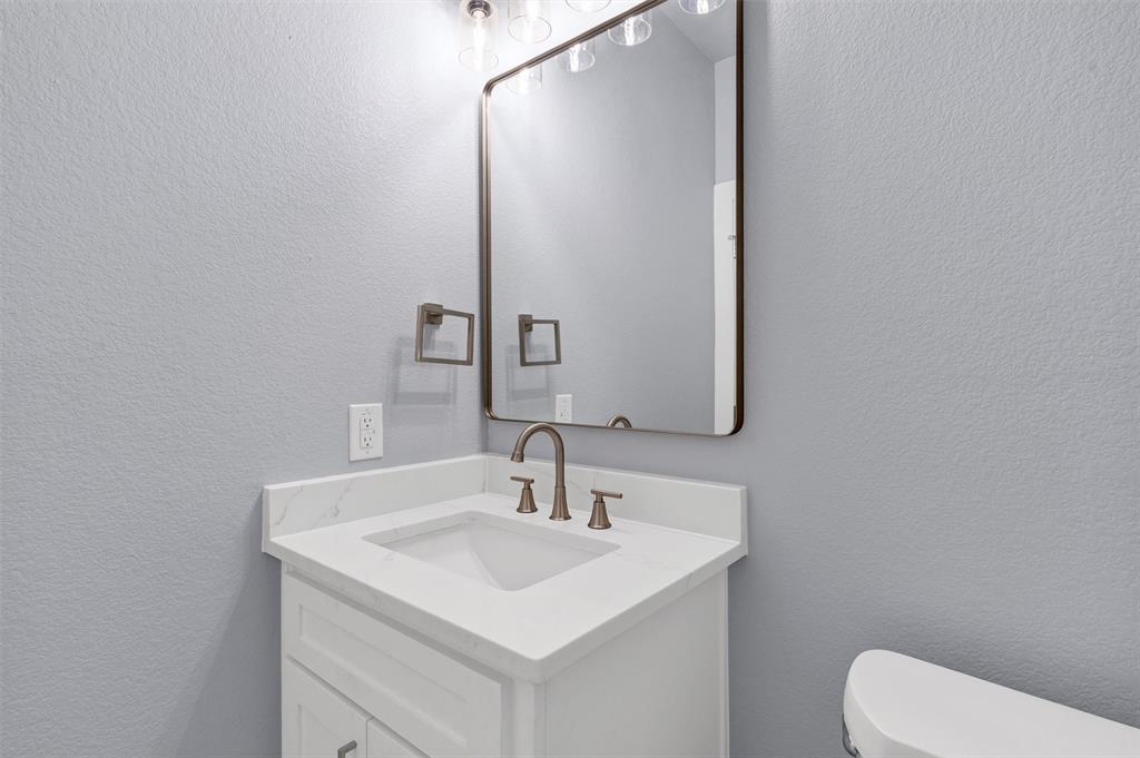 588 Highview Court Godley, TX 76044 - Photo 17 of 38 a bathroom with a toilet sink and mirror