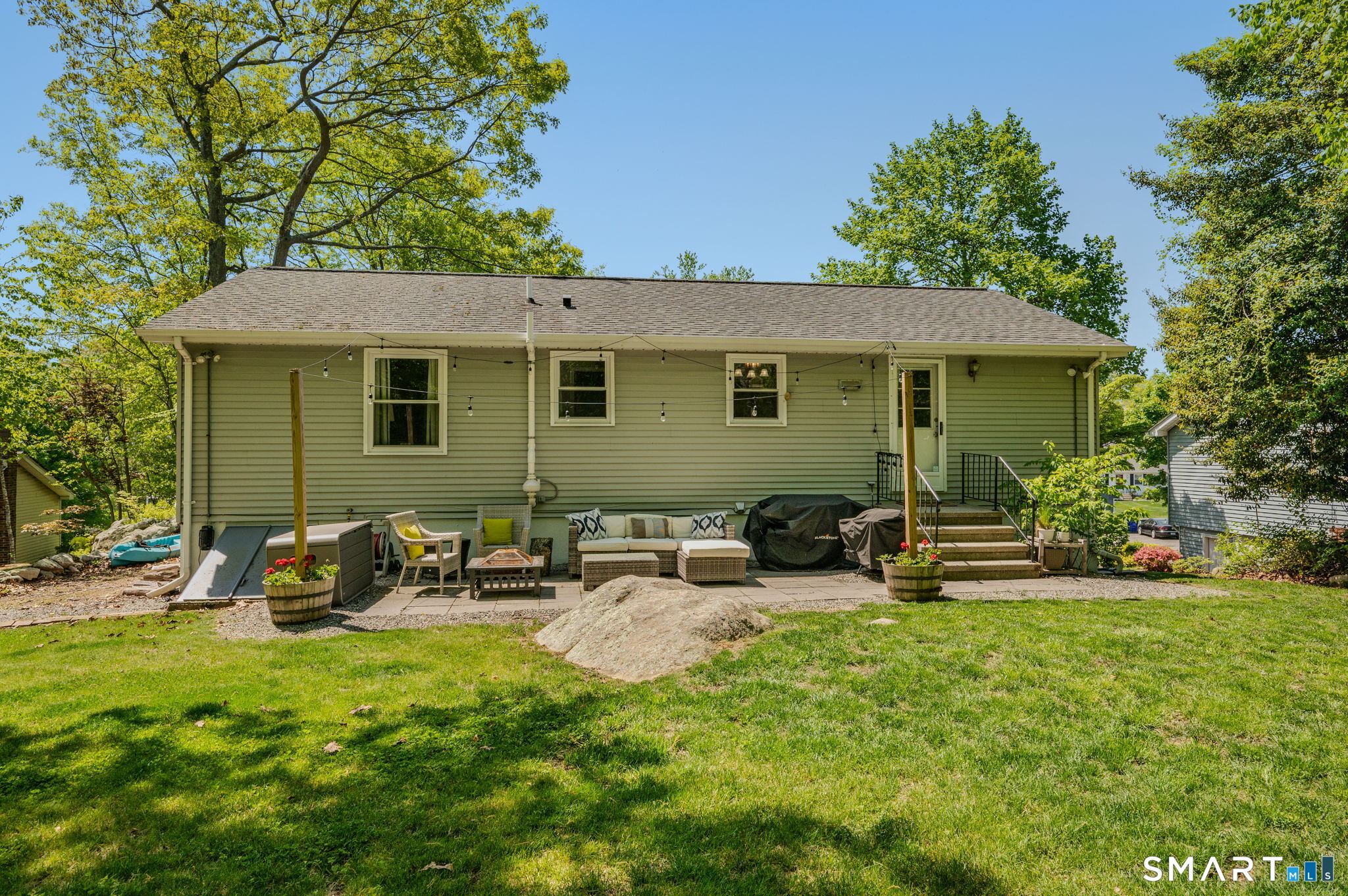 6 Amherst Court Groton, CT 06355 - Photo 31 of 40 a view of a backyard with table and chairs couches under an umbrella