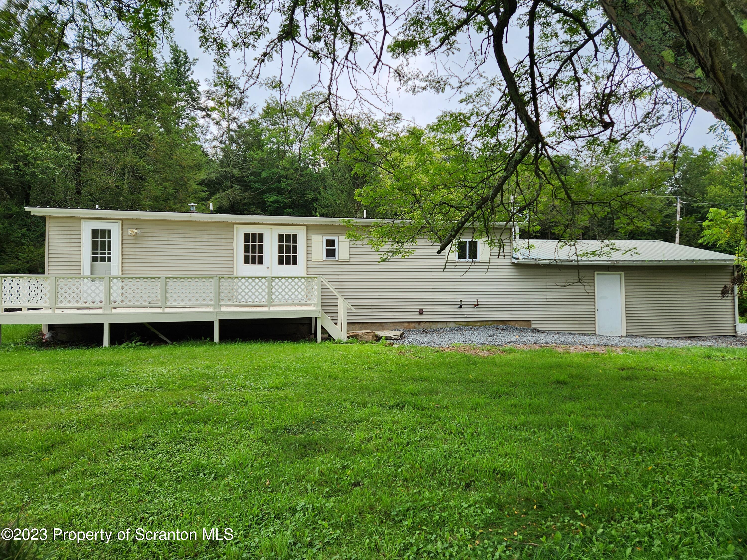 15325 Strickland Hill Road Springville, PA 18844 - Photo 2 of 20 a view of a backyard with plants and large trees