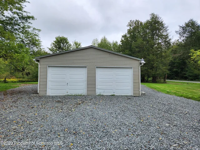 a view of a house with a yard and large tree