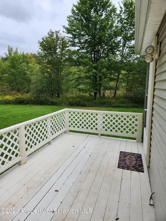 a wooden bench sitting in front of a yard