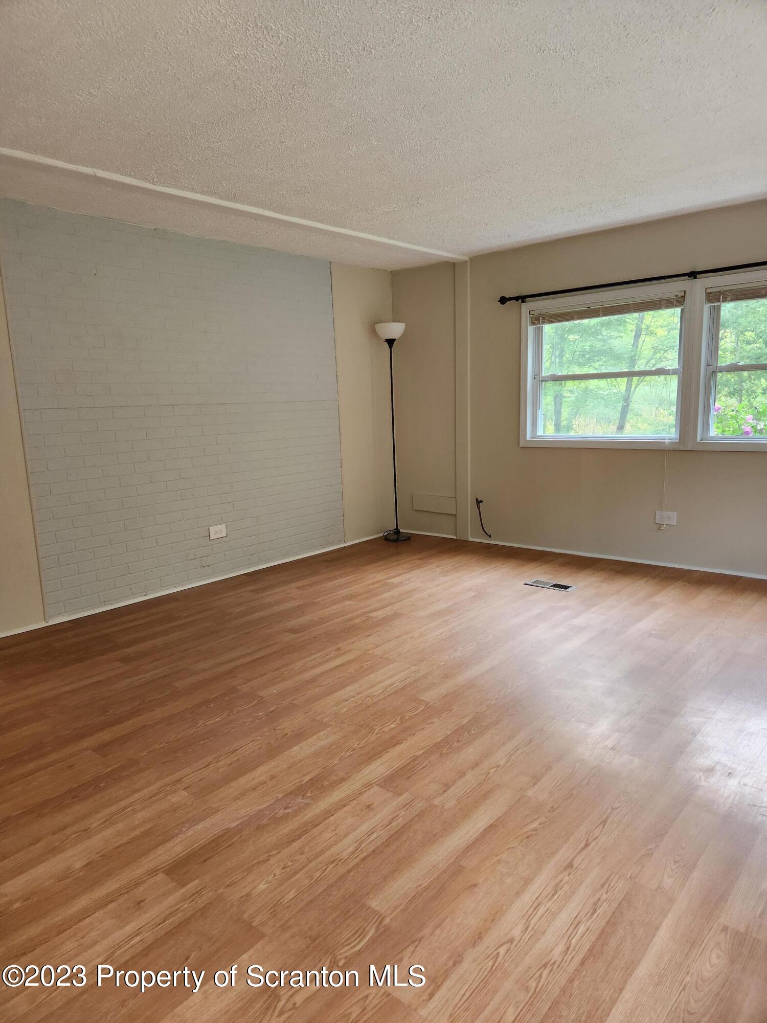 15325 Strickland Hill Road Springville, PA 18844 - Photo 10 of 20 an empty room with wooden floor and windows