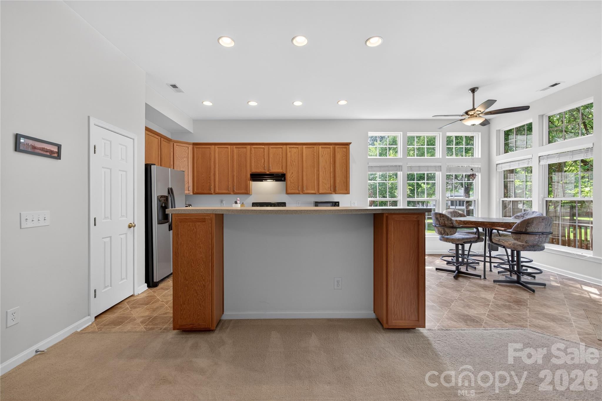 533 Fair Oaks Drive Fort Mill, SC 29708 - Photo 10 of 33 a kitchen with stainless steel appliances granite countertop a stove a refrigerator a sink a dining table and chairs with wooden floor