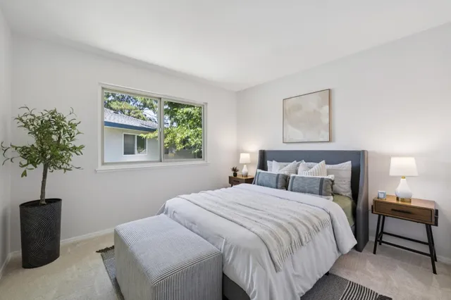 a bedroom with a bed and a potted plant