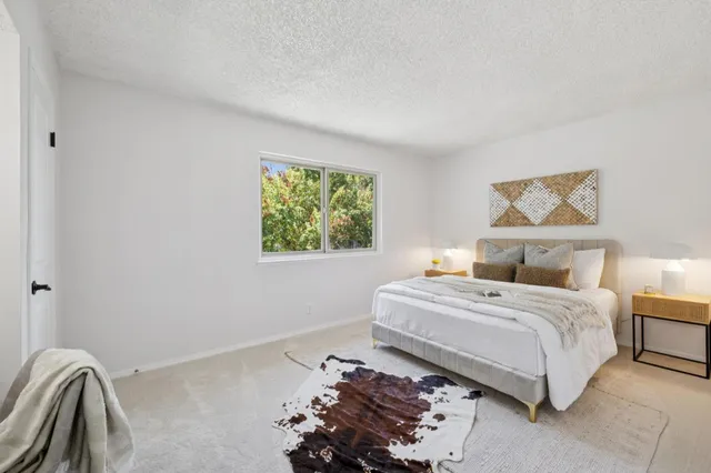 a bedroom with a bed and a painting on the wall