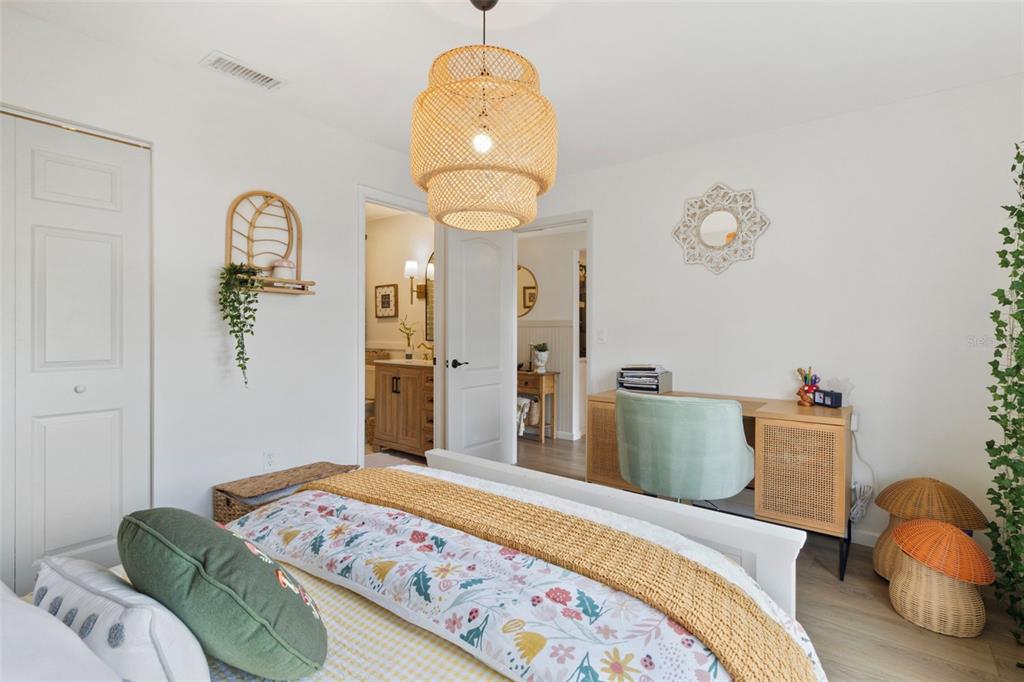 3641 Longmeadow, Unit 33 Sarasota, FL 34235 - Photo 14 of 18 a bedroom with a bed and a chandelier