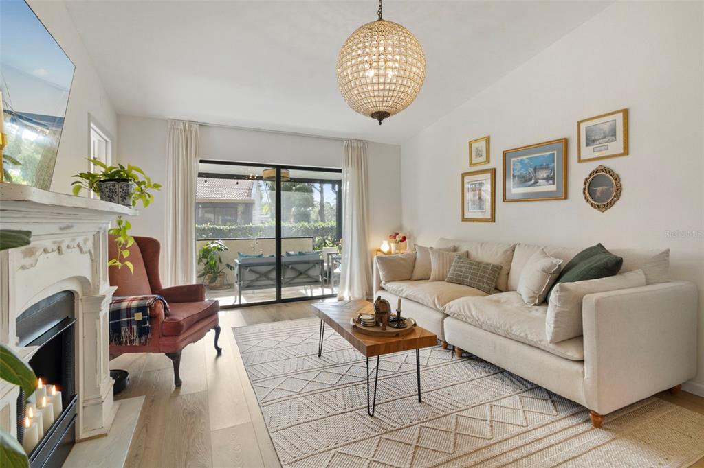 3641 Longmeadow, Unit 33 Sarasota, FL 34235 - Photo 7 of 18 a living room with furniture a fireplace and a large window