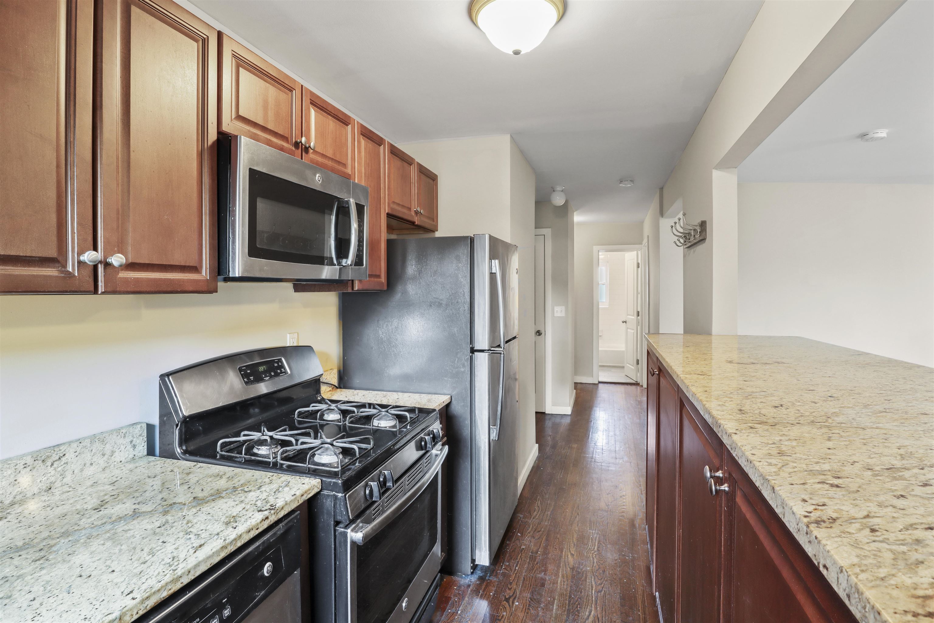a kitchen with stainless steel appliances granite countertop a stove top oven microwave and refrigerator