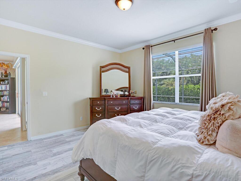 8143 Monticello Court Naples, FL 34104 - Photo 12 of 26 a bedroom with a bed and a large window